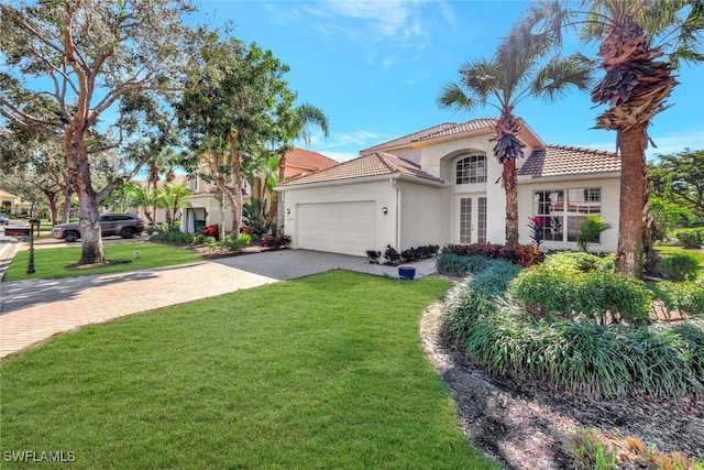 mediterranean / spanish home with a garage and a front yard