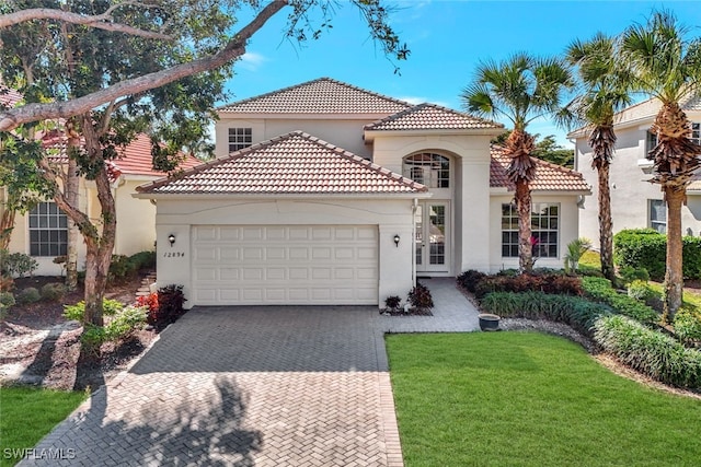 mediterranean / spanish home with a garage and a front yard