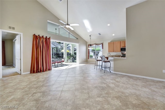 unfurnished living room with high vaulted ceiling, light tile patterned floors, and ceiling fan