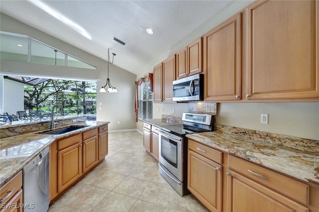 kitchen featuring sink, vaulted ceiling, hanging light fixtures, light tile patterned floors, and stainless steel appliances