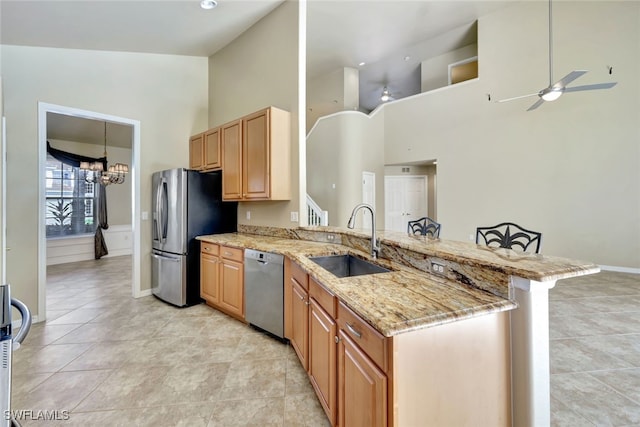 kitchen with sink, a kitchen breakfast bar, kitchen peninsula, and appliances with stainless steel finishes