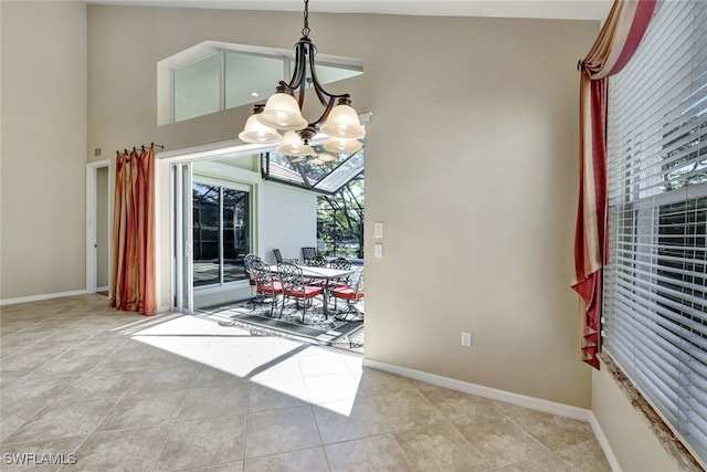 dining space featuring light tile patterned flooring, a chandelier, a high ceiling, and a wealth of natural light