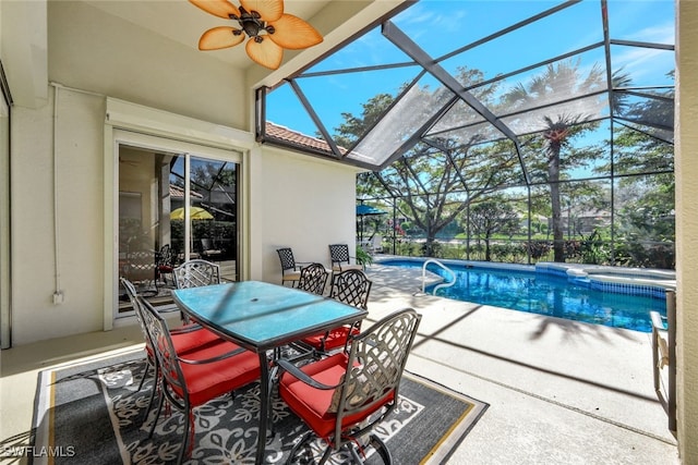 view of swimming pool featuring a patio area, ceiling fan, and glass enclosure