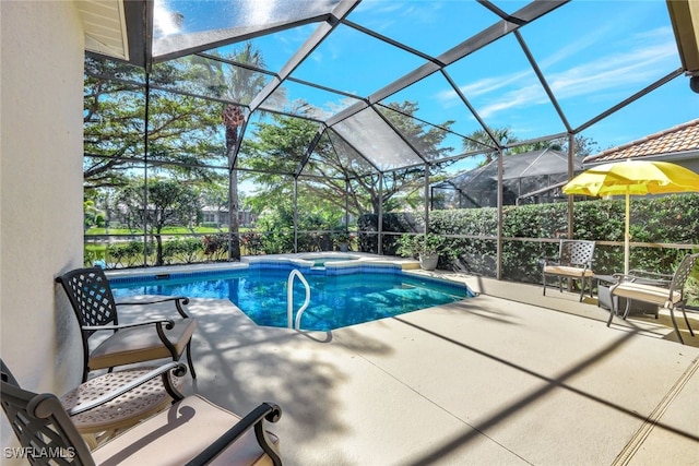 view of pool featuring an in ground hot tub, a patio area, and glass enclosure