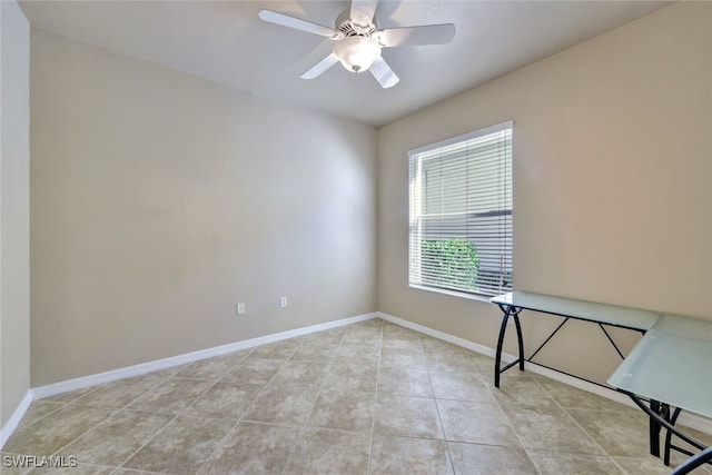 empty room with ceiling fan and light tile patterned floors