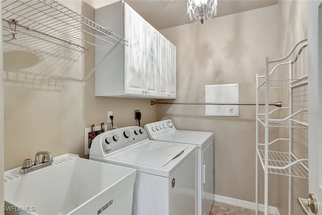 clothes washing area with cabinets, sink, and washer and dryer