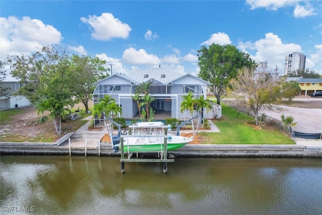 back of property featuring a lawn, a balcony, a water view, and a lanai