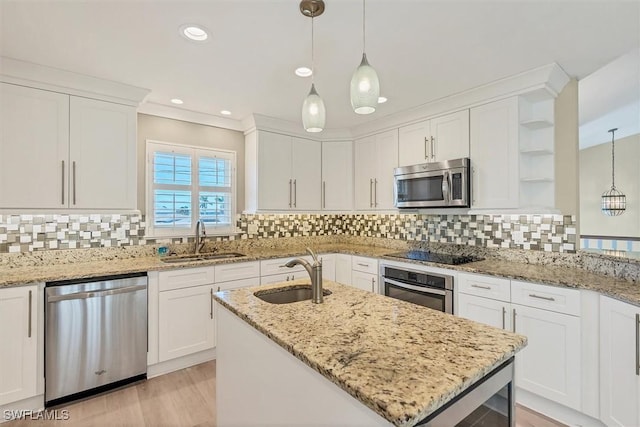 kitchen with white cabinets, light stone counters, sink, and appliances with stainless steel finishes