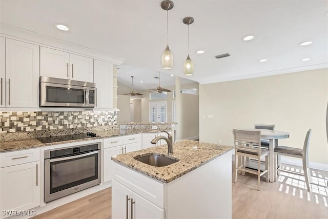 kitchen with white cabinets, ceiling fan, decorative backsplash, and appliances with stainless steel finishes