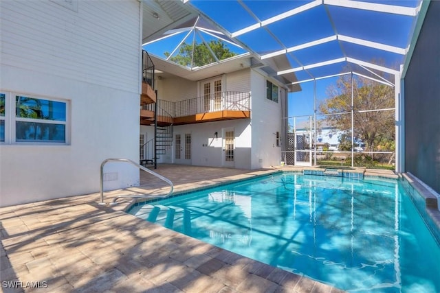 view of swimming pool with glass enclosure, an in ground hot tub, french doors, and a patio