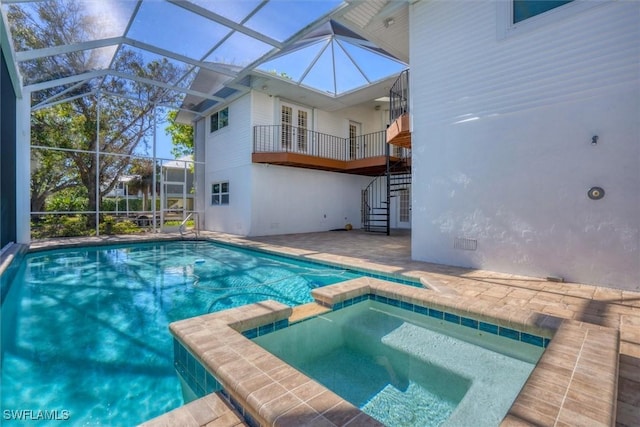 view of pool featuring an in ground hot tub, a patio area, and a lanai