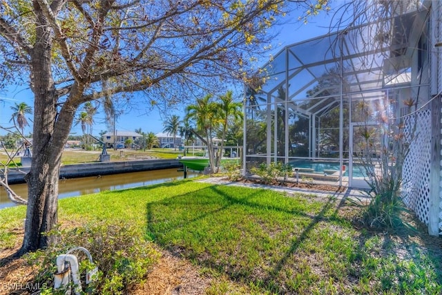 view of yard with a lanai and a water view