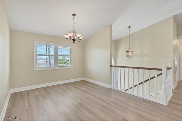 unfurnished room featuring light hardwood / wood-style flooring and an inviting chandelier