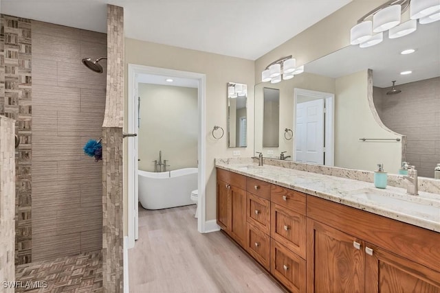 bathroom with hardwood / wood-style flooring, vanity, and separate shower and tub