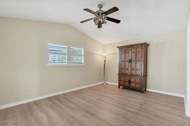 spare room featuring ceiling fan, light wood-type flooring, and lofted ceiling