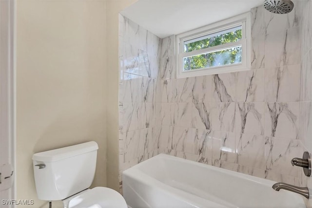 bathroom with tiled shower / bath combo and toilet