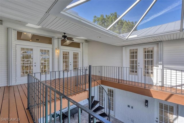 wooden deck featuring french doors, glass enclosure, and ceiling fan