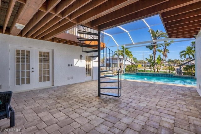 view of swimming pool featuring glass enclosure, a patio, and french doors