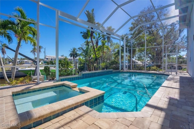 view of swimming pool featuring an in ground hot tub and a lanai