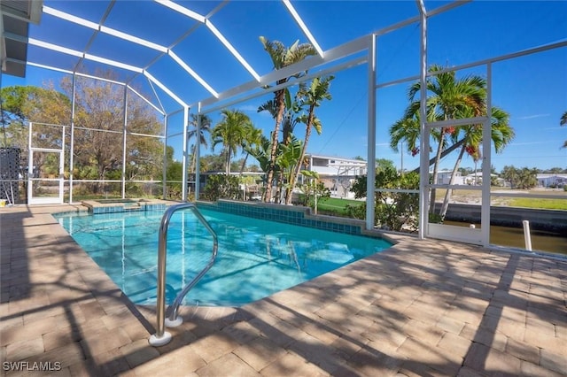 view of pool with a jacuzzi, a patio, and a lanai