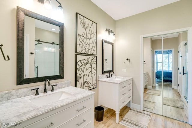 bathroom with a shower, wood-type flooring, and vanity