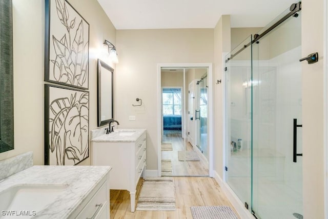 bathroom featuring hardwood / wood-style floors, vanity, and a shower with door