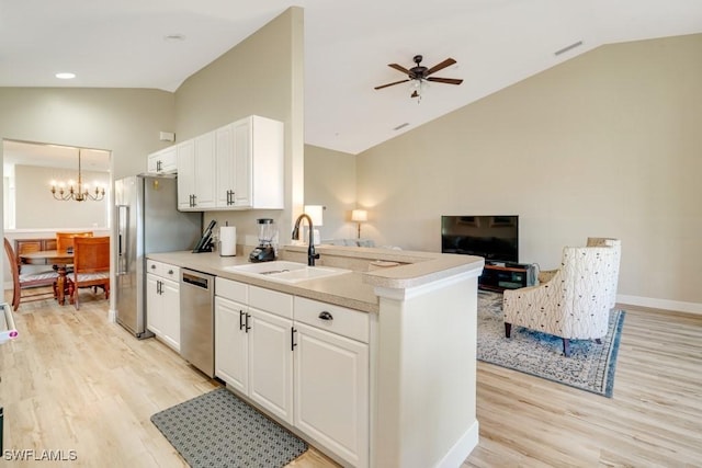 kitchen with white cabinets, appliances with stainless steel finishes, lofted ceiling, and sink