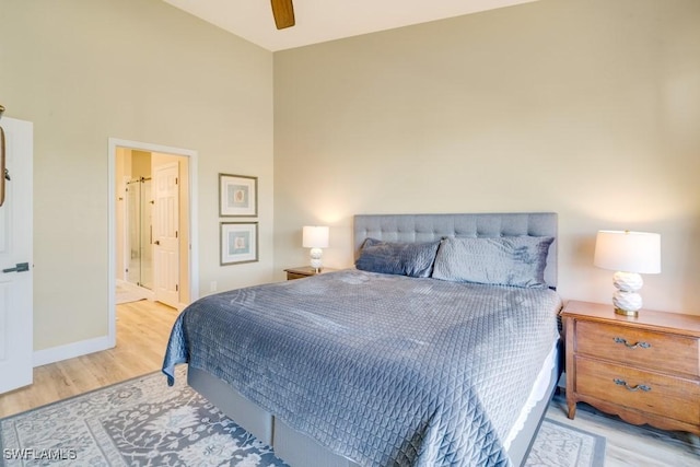 bedroom with connected bathroom, light hardwood / wood-style flooring, and ceiling fan