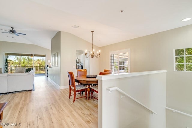 dining space featuring a wealth of natural light, light hardwood / wood-style flooring, ceiling fan with notable chandelier, and lofted ceiling