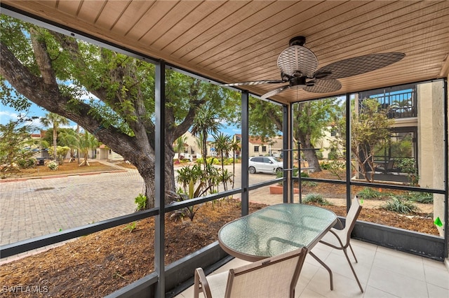 sunroom featuring ceiling fan and wooden ceiling