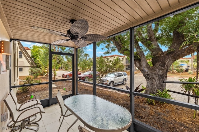 unfurnished sunroom with ceiling fan and wood ceiling