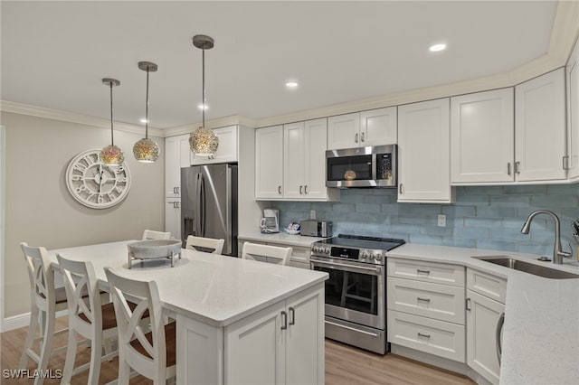 kitchen with appliances with stainless steel finishes, sink, light stone counters, and white cabinetry