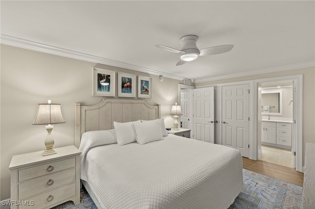 bedroom featuring ceiling fan, ensuite bath, wood-type flooring, and crown molding