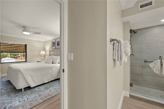 bedroom featuring ceiling fan, wood-type flooring, and crown molding