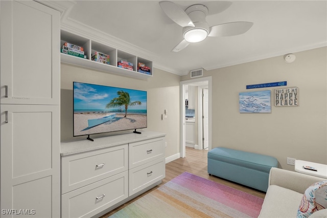 living room featuring ceiling fan, light hardwood / wood-style flooring, and crown molding