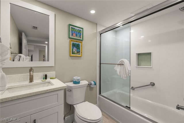 full bathroom featuring toilet, combined bath / shower with glass door, and vanity