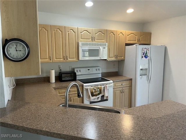 kitchen with white appliances, light brown cabinetry, and sink