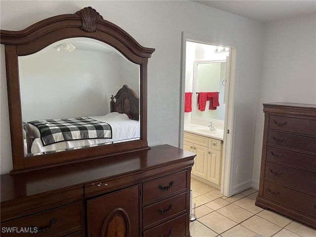 bedroom with ensuite bath, light tile patterned flooring, and sink