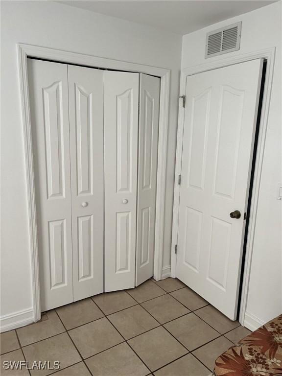 unfurnished bedroom with a closet and light tile patterned floors