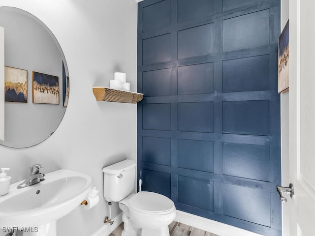 bathroom with hardwood / wood-style flooring, toilet, and sink