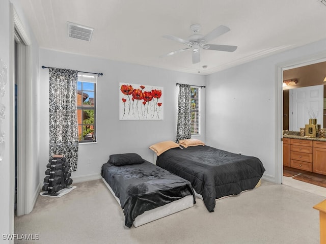 carpeted bedroom with ensuite bathroom and ceiling fan