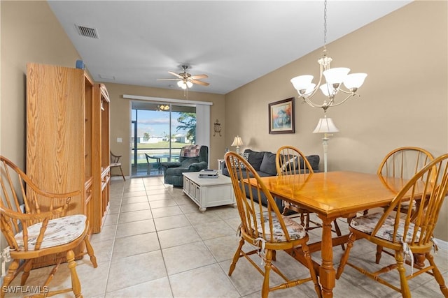 tiled dining space with ceiling fan with notable chandelier