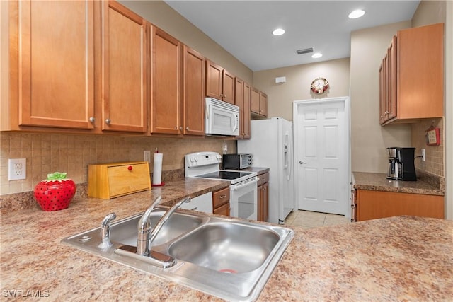 kitchen with white appliances, sink, light tile patterned floors, and tasteful backsplash