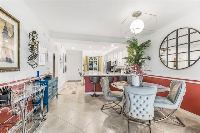 dining area with light tile patterned floors, sink, and a chandelier