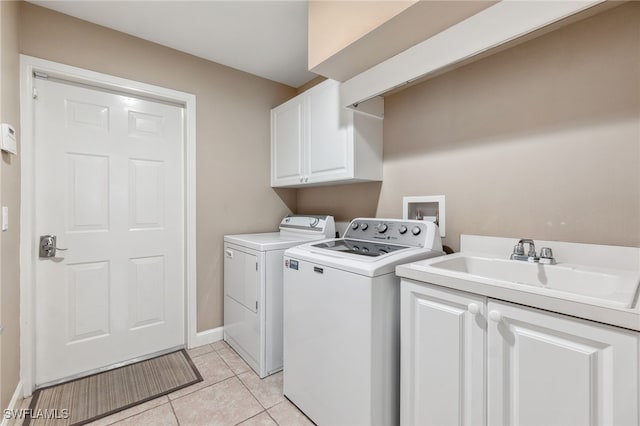 laundry area featuring a sink, cabinet space, light tile patterned flooring, and washer and clothes dryer