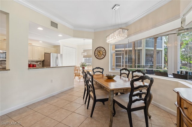 dining area featuring light tile patterned floors, crown molding, and a chandelier