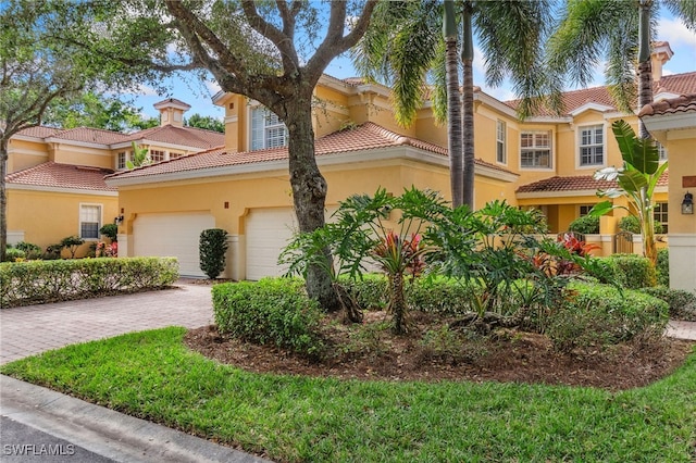 view of front facade with stucco siding, decorative driveway, and a garage