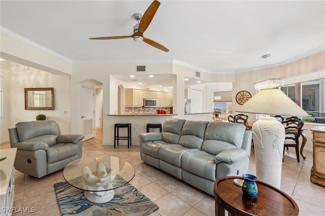 living room with light tile patterned floors, ceiling fan, and crown molding