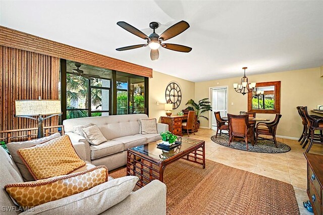 tiled living room with ceiling fan with notable chandelier