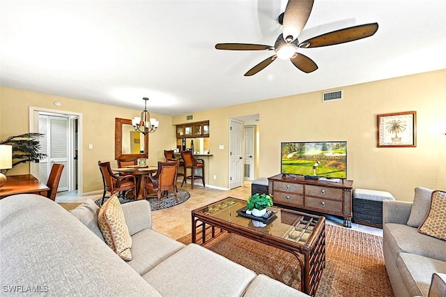 living room with light tile patterned floors, baseboards, visible vents, and ceiling fan with notable chandelier